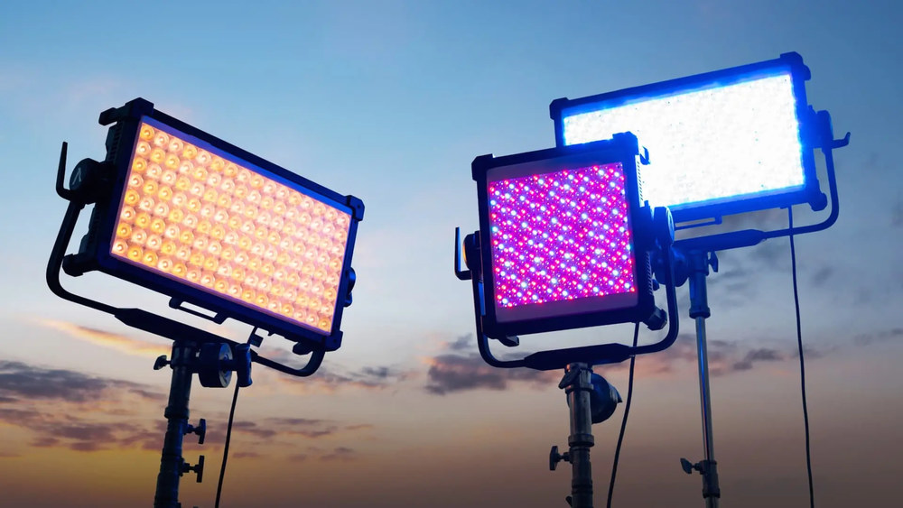 Три RGB LED-панели на стойках с тёплым, холодным и розовым цветом свечения на фоне закатного неба